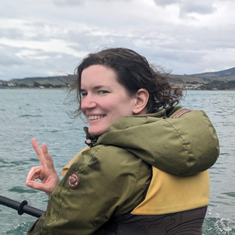 Anne-Christine zeigt das Peace-Zeichen beim Paddeln auf dem See.